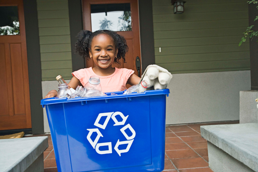 Girl holding a recycling bin 