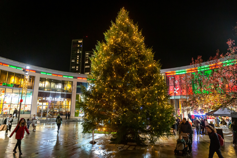 Woking town centre's 2023 Christmas tree lit up in Jubilee Square in the evening.