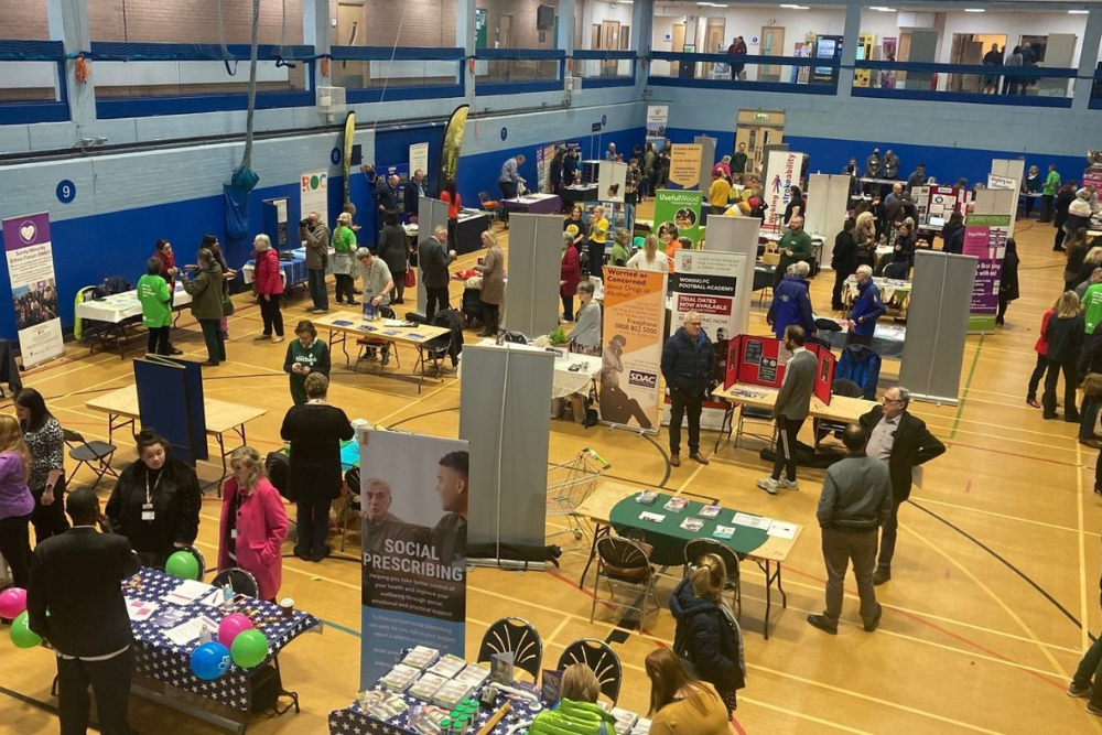 A busy hall full of stall holders and visitors 