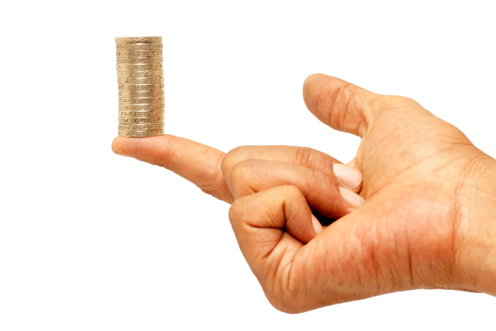 Image of a human's hand balancing money on one fingertip